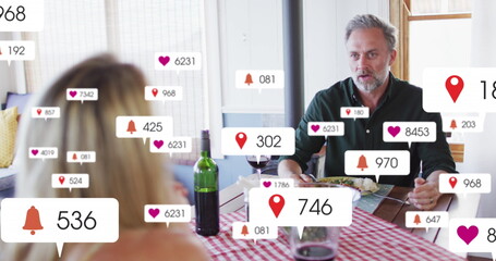 Image of social media icons and numbers over senior caucasian couple at home