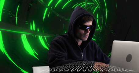Image of digital interface with male hacker in hooded top and sunglasses using laptop and green glow