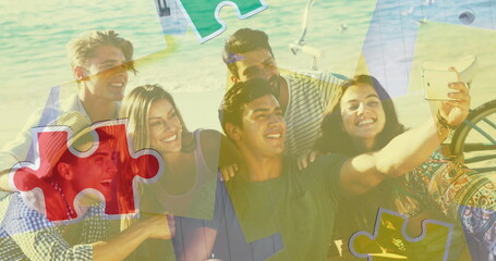 Image of colourful puzzle pieces and human head over happy friends at summer beach party