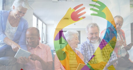 Image of colourful puzzle pieces ribbon over senior friends using tablets