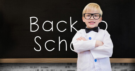 Image of back to school text and schoolboy over blackboard