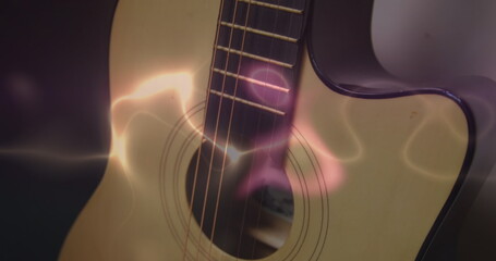 Fototapeta premium Image of white, blue and pink light trails over acoustic guitar on smokey background