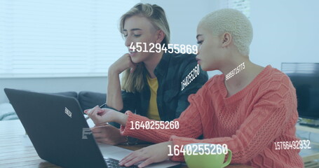 Image of numbers changing over caucasian women using laptop