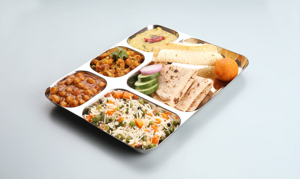 Assorted indian food for lunch or dinner, rice, lentils, paneer butter masala, palak panir, dal makhani, naan, green salad