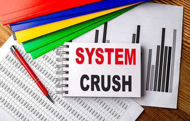 SYSTEM CRUSH text on a notebook with pen, folder on a chart background