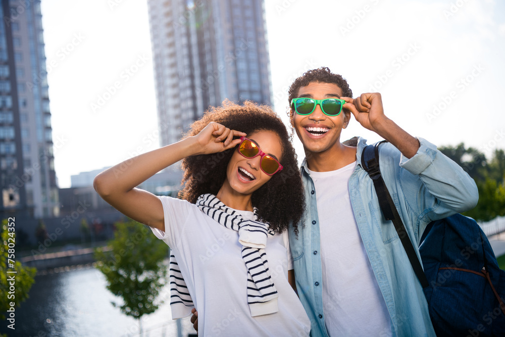 Canvas Prints portrait of two overjoyed best friends tourists touching sunglass in warm sunny day outdoors wearing