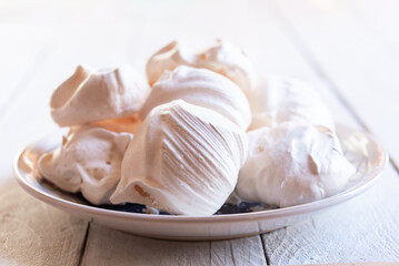 Fototapeta na wymiar Homemade meringues on plate on white background