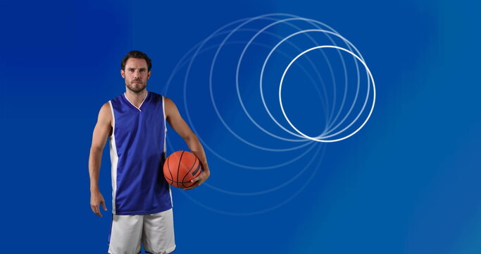 Image of circles over male basketball player holding ball