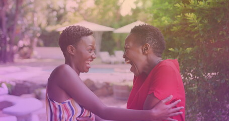 Two african american sisters hugging each other at a resort
