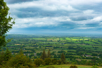 Beautiful landscape of rural Irealand with green fields and moody blue sky