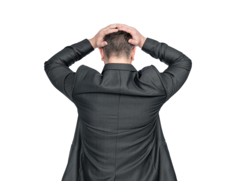 A depressed man in a dark suit stands holding his head with both hands, rear view. Isolated on a transparent background png