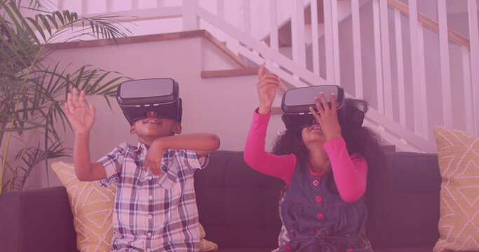 Image of smiling african american siblings using vr headsets - Powered by Adobe