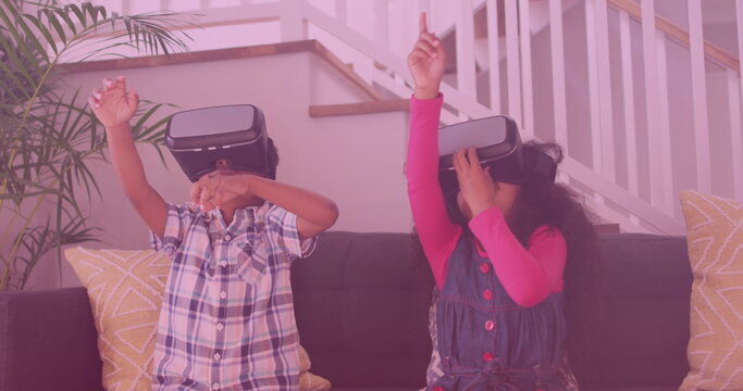 Image of smiling african american siblings using vr headsets