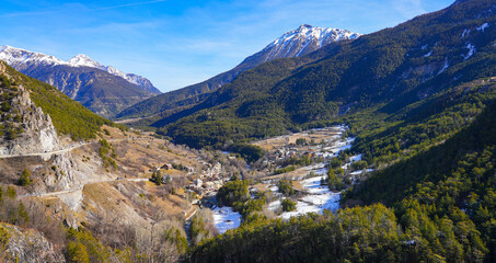 Alpine village of Le Fontenil overlooked by the snow capped Crête de Château Jouan near Montgenèvre above Briançon in the French Alps in winter