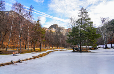 Frozen lake of the Parc de la Schappe overlooked by the Vauban citadel of Briançon, a small town...