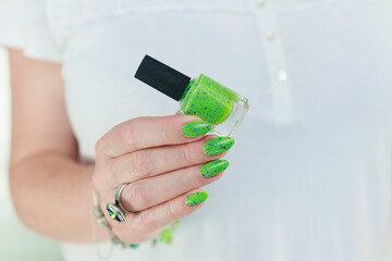 Female hand with long nails and neon green manicure