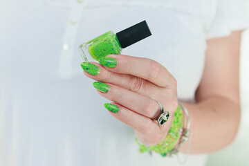 Female hand with long nails and neon green manicure