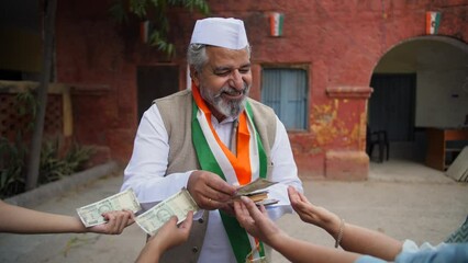 An Indian politician distributing money to poor people - corrupted schemes  voting fraud  election manipulation. A political party leader gives away his wealth to the citizens after winning the ele...