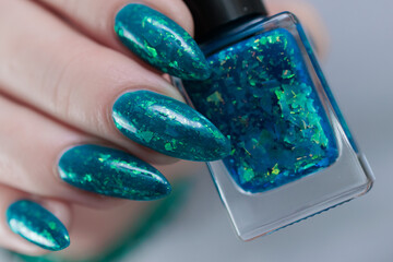Woman hand with long nails and teal blue green manicure
