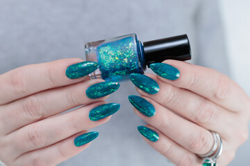 Woman hand with long nails and teal blue green manicure