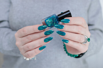 Woman hand with long nails and teal blue green manicure