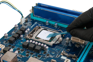 Engineer applies thermal paste to a processor installed in a socket on a printed circuit board....