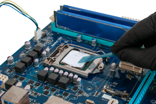 Engineer applies thermal paste to a processor installed in a socket on a printed circuit board. Computer equipment maintenance concept, cut out