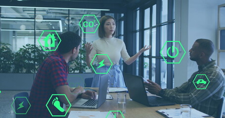 Image of icon in hexagons over diverse woman explaining strategy to coworkers in office - Powered by Adobe