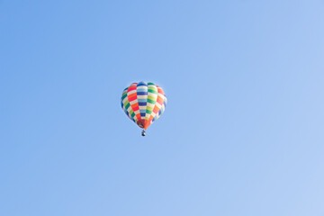 Fototapeta premium Hot air balloons landing in a mountain flight over field and forest,colorful Hot air balloons flying over the valley with blue sky,Tourism concept.