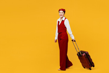 Full body young stewardess flight attendant woman of Asian ethnicity wears red vest shirt hat hold...