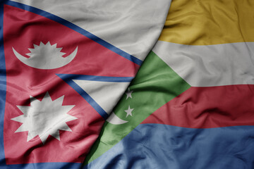 big waving national colorful flag of comoros and national flag of nepal .