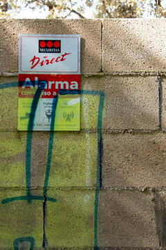 Alarm warning sign attached to a fence or wall