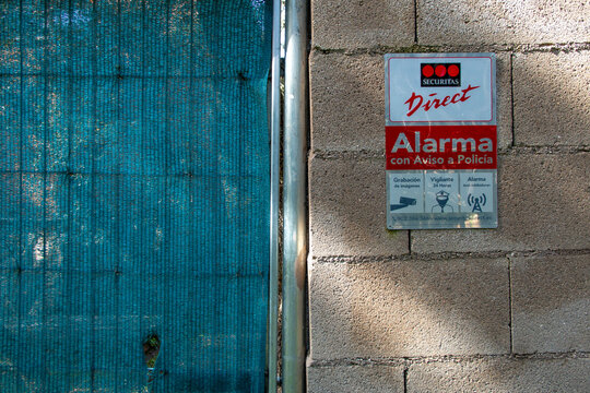 Alarm warning sign attached to a fence or wall