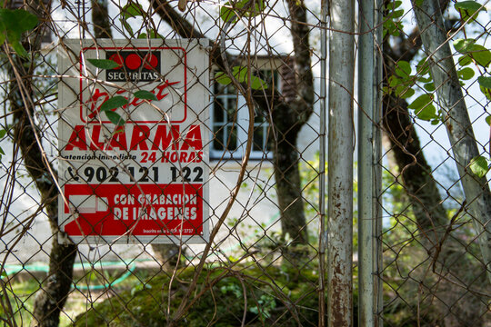 Alarm warning sign attached to a fence or wall