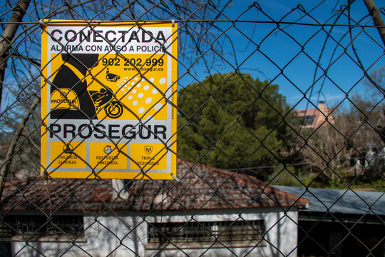 Alarm warning sign attached to a fence or wall