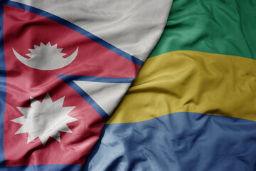 big waving national colorful flag of gabon and national flag of nepal .