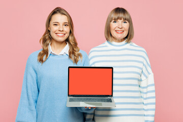 Elder happy parent mom with young adult IT daughter two women together wear blue casual clothes hold use work on blank screen laptop pc computer isolated on plain pink background. Family day concept.