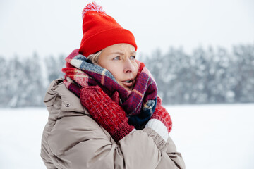 Fototapeta na wymiar Woman red hat and checkered scarf feeling cold and shivering