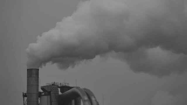 environmental problems - a large factory pipe strongly smokes and emits harmful substances into the air