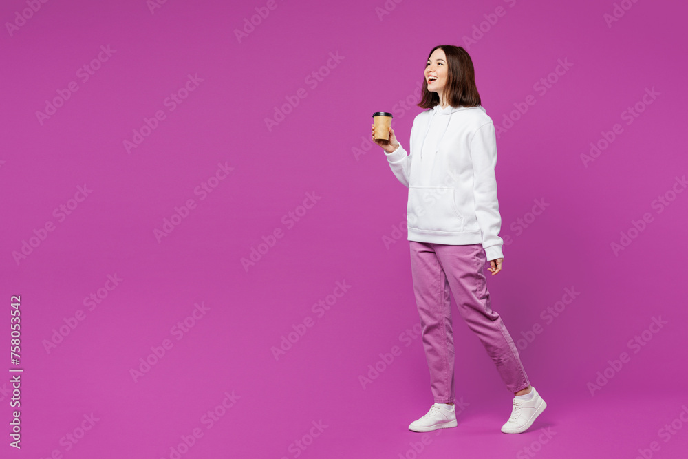 Poster Full body young smiling happy woman she wear light hoody casual clothes hold takeaway delivery craft paper brown cup coffee to go isolated on plain purple color background studio. Lifestyle concept.