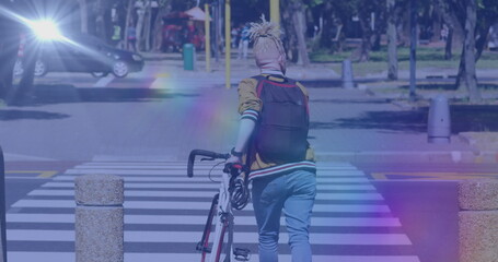 Image of light spots over albino african american man walking with bicycle