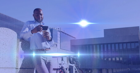 Image of light spots over african american man using smartphone