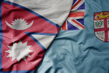 big waving national colorful flag of Fiji and national flag of nepal .