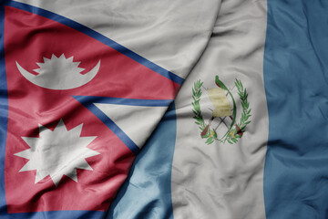 big waving national colorful flag of guatemala and national flag of nepal .