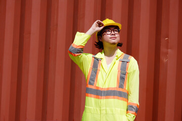 Young male engineer in yellow safety helmet working in container industry.