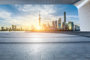 Empty square floor and city skyline with modern buildings at sunrise in Shanghai