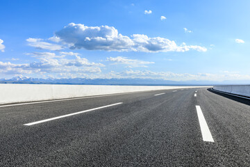 Asphalt highway road and mountains with sky clouds background