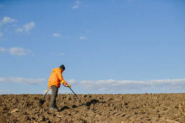 Man with a metal detector in the field. Search for treasures.
