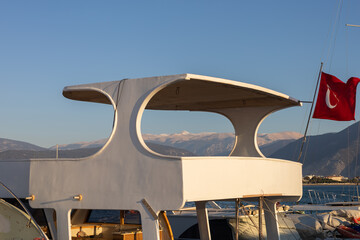 Contemporary yacht architecture highlighted by the backdrop of distant mountains.