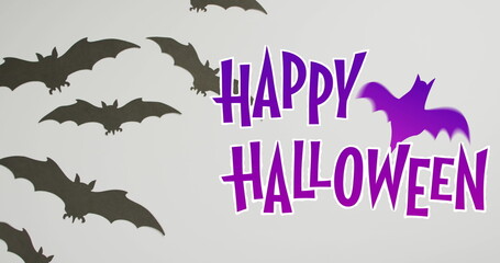 Obraz premium Happy halloween text banner with bat icon against multiple bat toys on grey surface